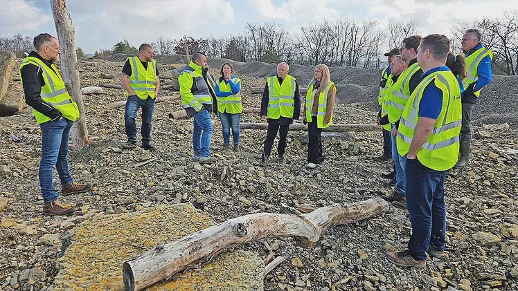 Teilnehmer des Pressetermins im Steinbruch Oberthulba, im Vordergrund ein Baumstamm