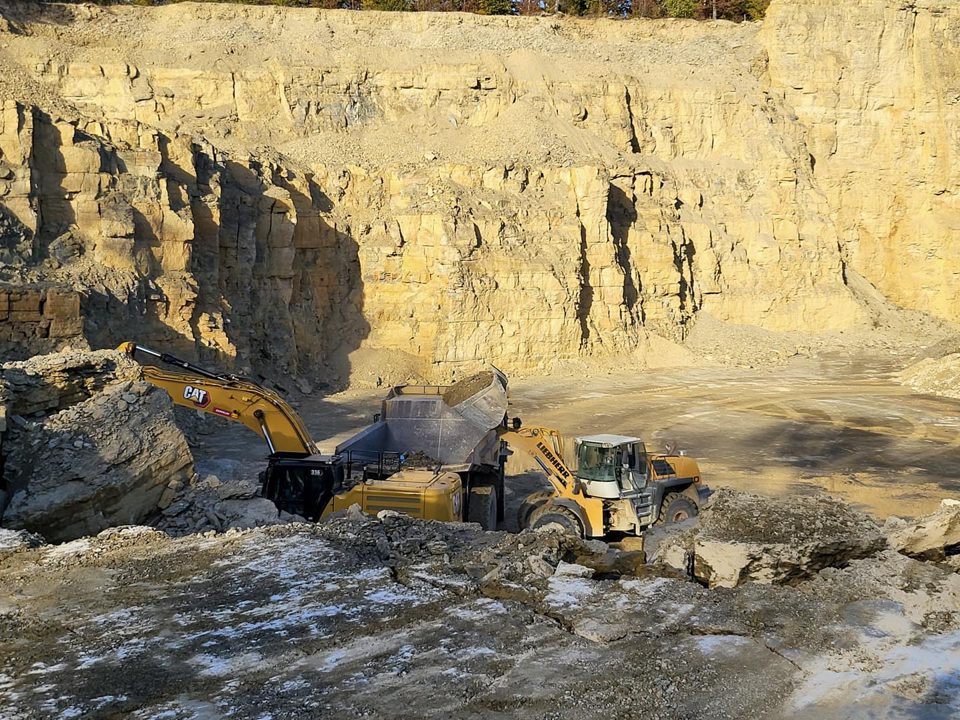 Radlader und Bagger vor der Kalksteinwand im Werk Oberthulba